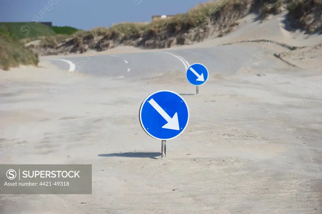 Driving direction signs on sandy beach at start of road, Romo, Wadden Sea Islands, Denmark, may