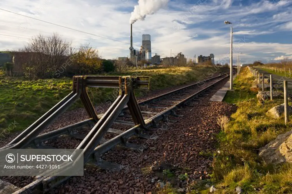 Deserted railroad track with a cement factory in the background, Dunbar, East Lothian, Scotland