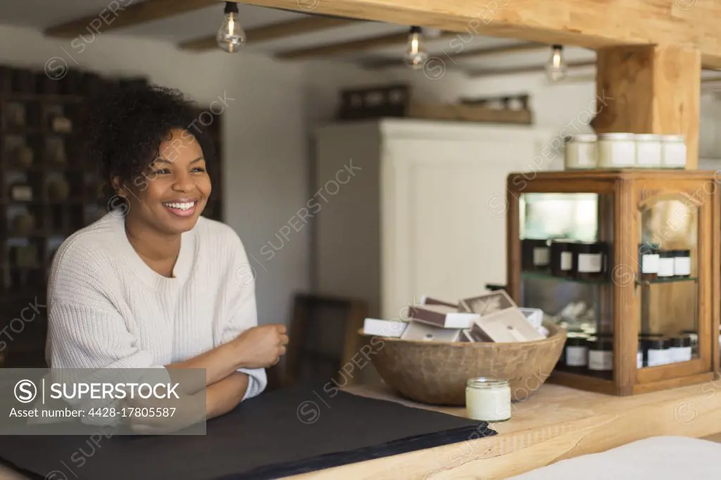 Portrait happy confident female shop owner at counter