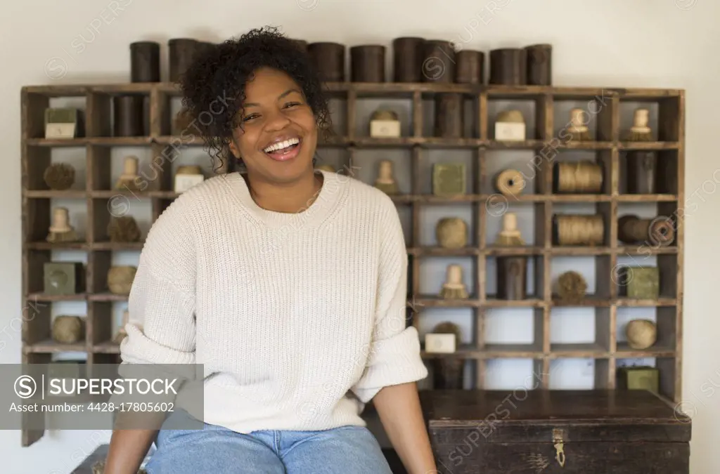 Portrait happy female shop owner at vintage display