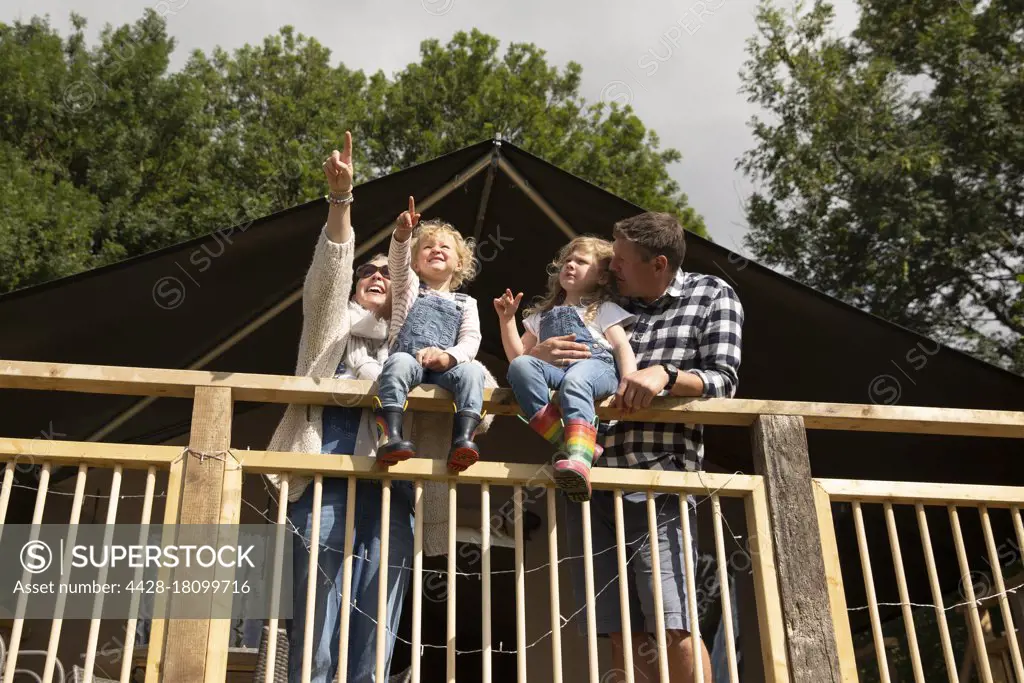 Happy family at sunny cabin railing