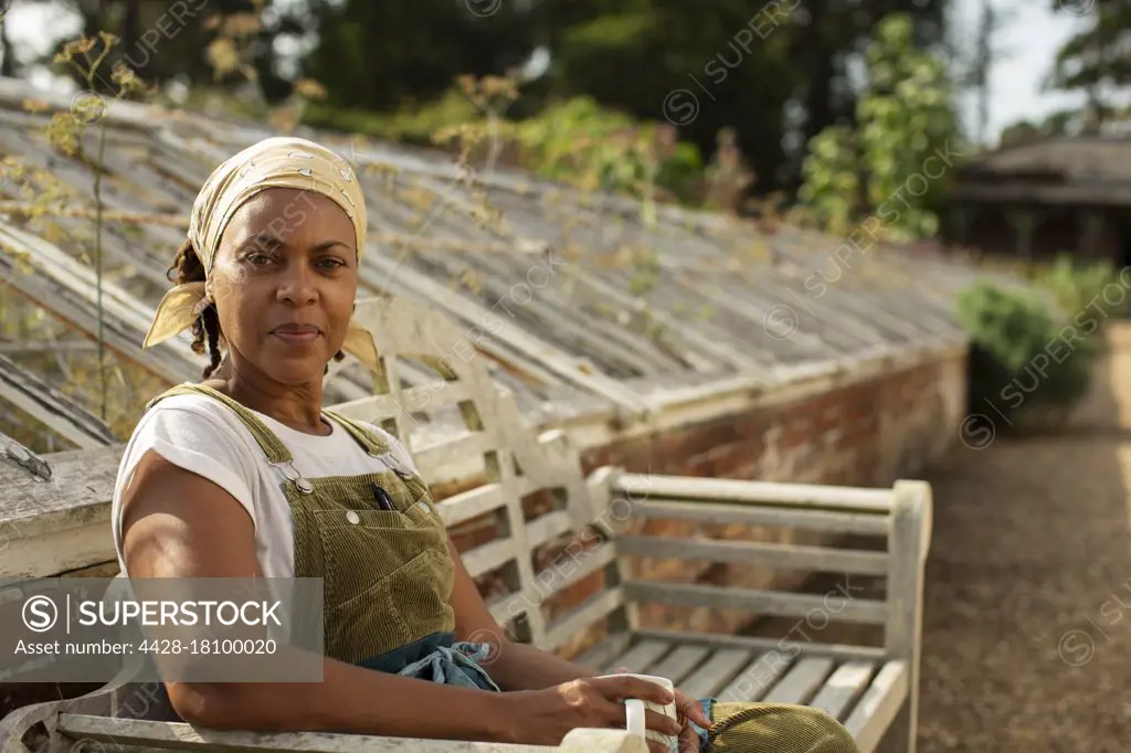 Portrait confident female plant nursery owner taking coffee break