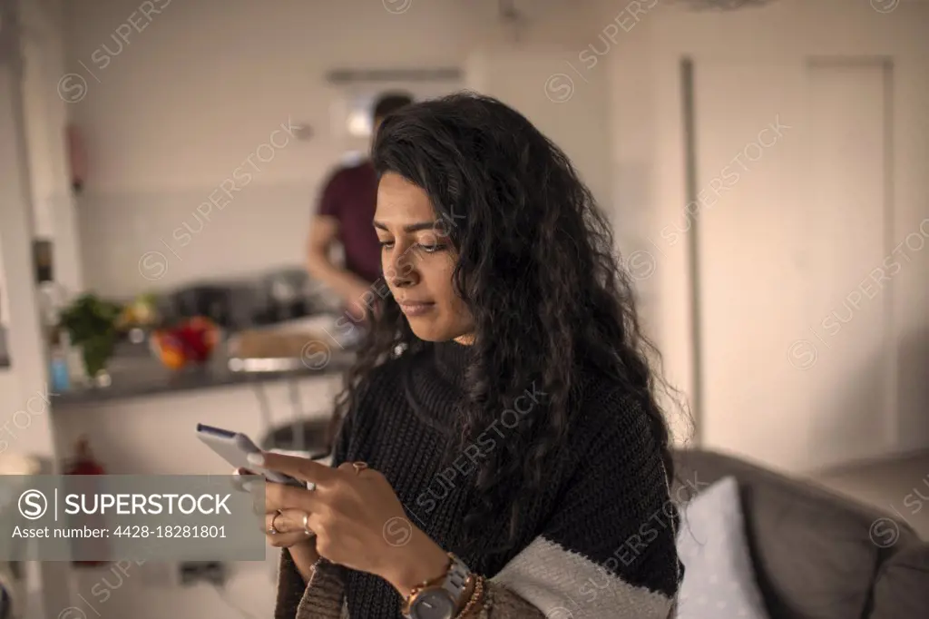 Woman using smart phone at home