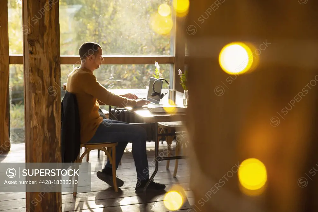 Businessman working at laptop at cafe table