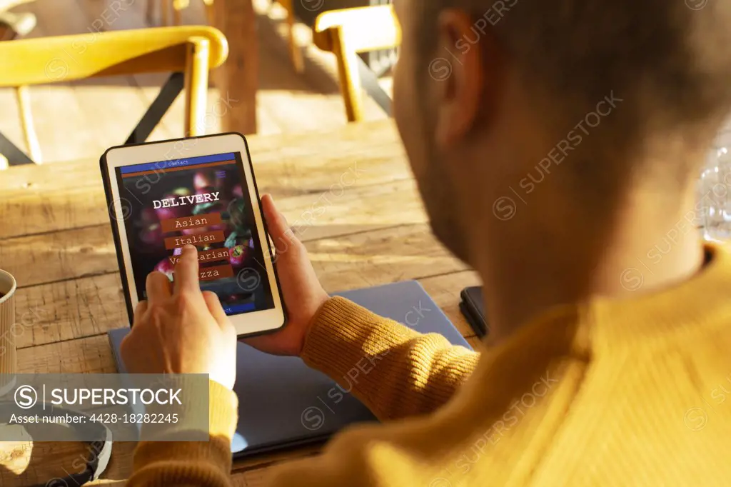 Man with digital tablet ordering food by app on digital tablet