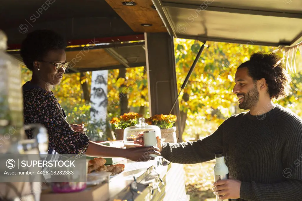 Food cart owner serving coffee to customer