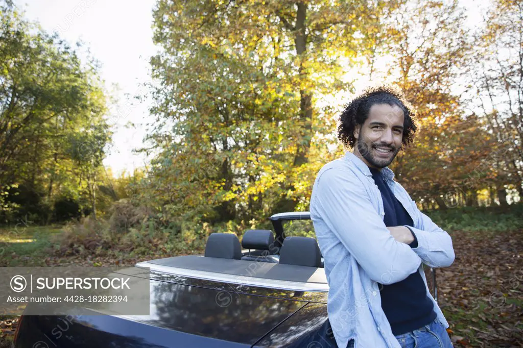 Portrait happy man at convertible in autumn park