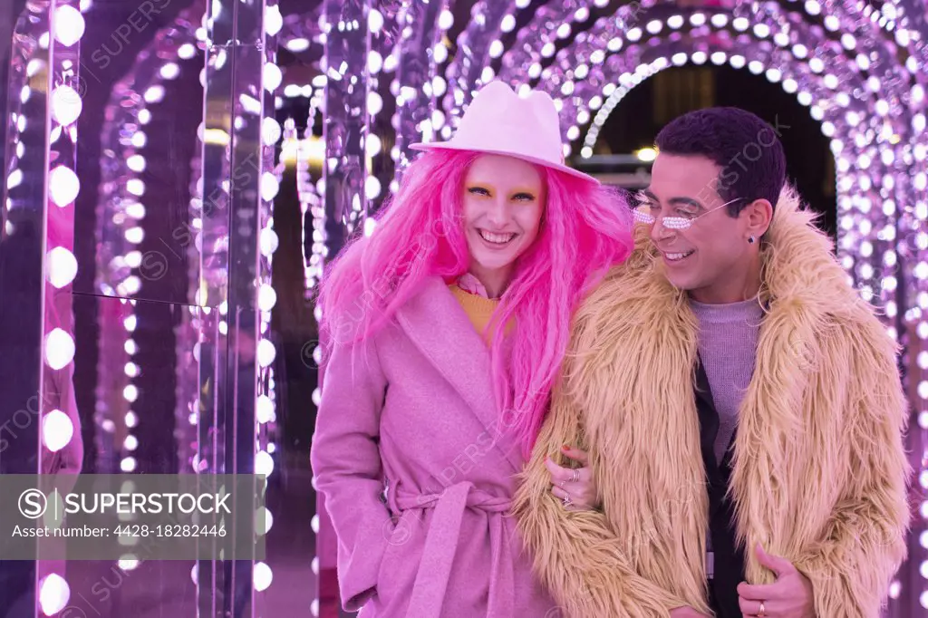 Portrait fashionable couple under illuminated arch