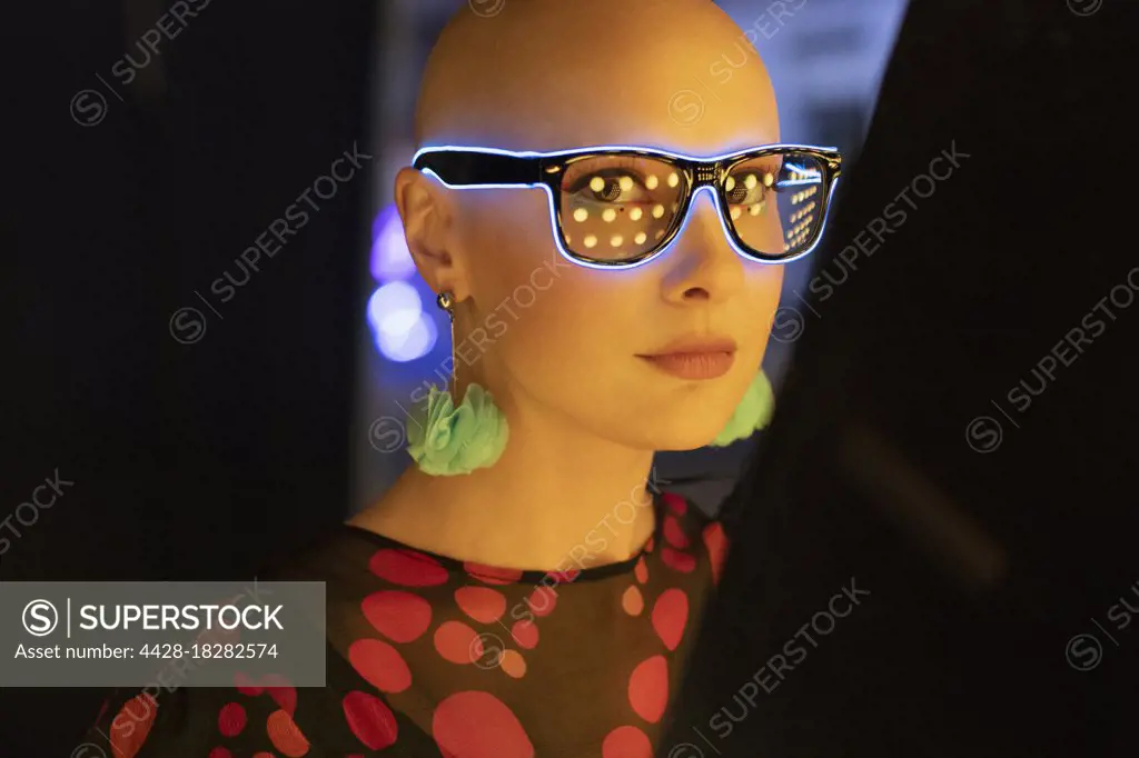 Portrait stylish woman in neon glasses and earrings