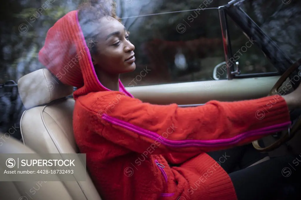 Stylish young woman driving convertible