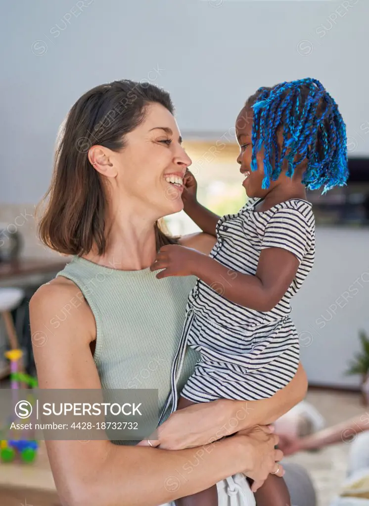 Happy mother holding cute toddler daughter