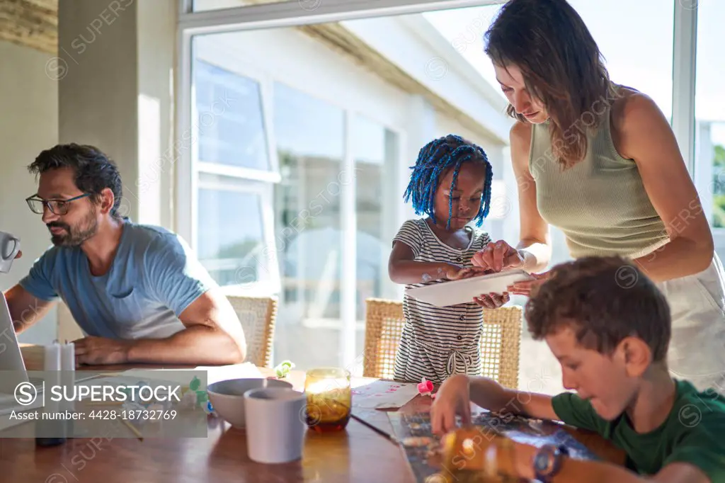 Family working and playing at dining table