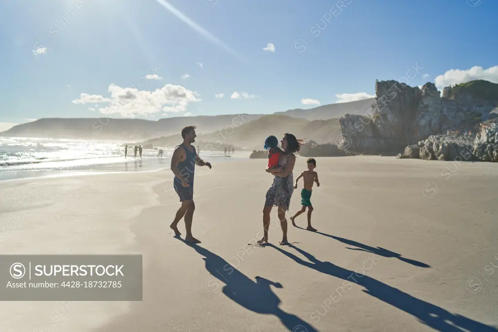 Family playing on sunny summer beach