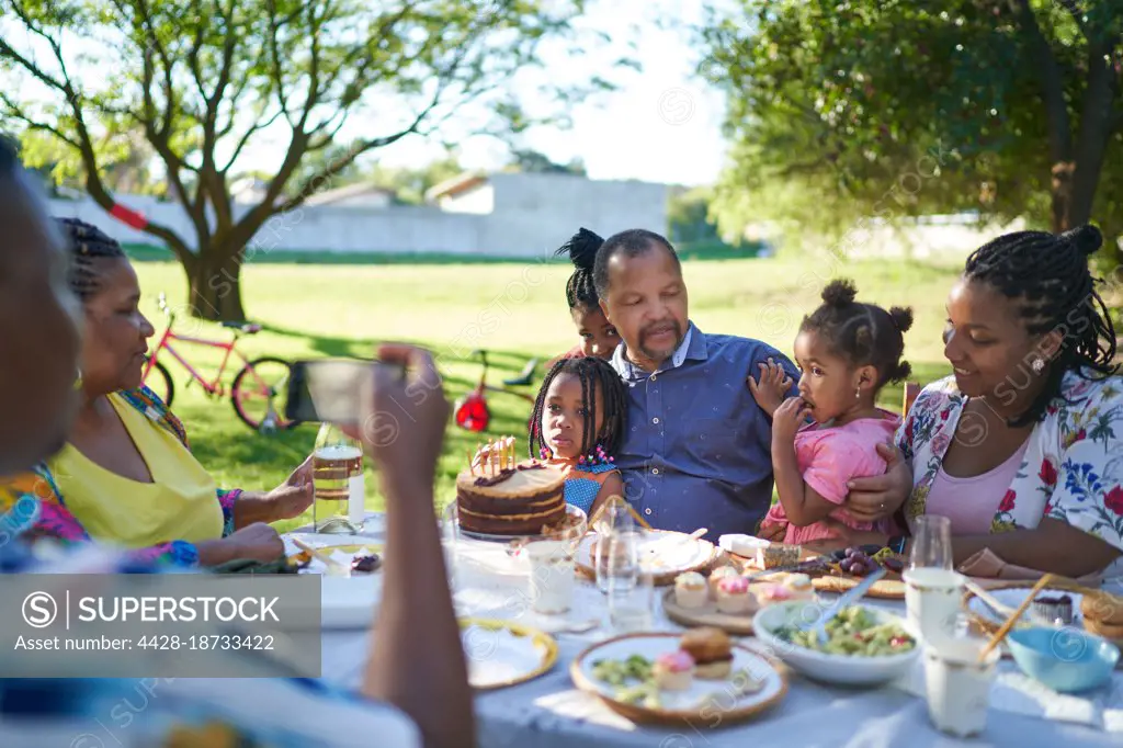 Multigenerational family enjoying birthday lunch in summer backyard