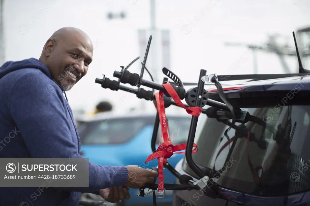 Portrait happy man at bike rack on car