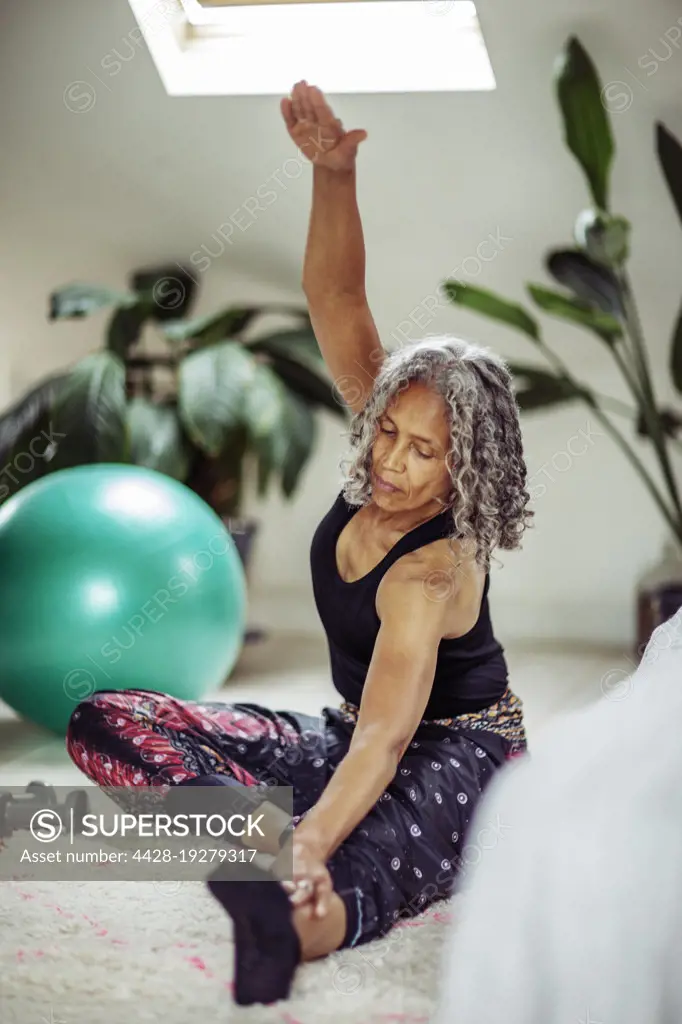 Senior woman stretching at home