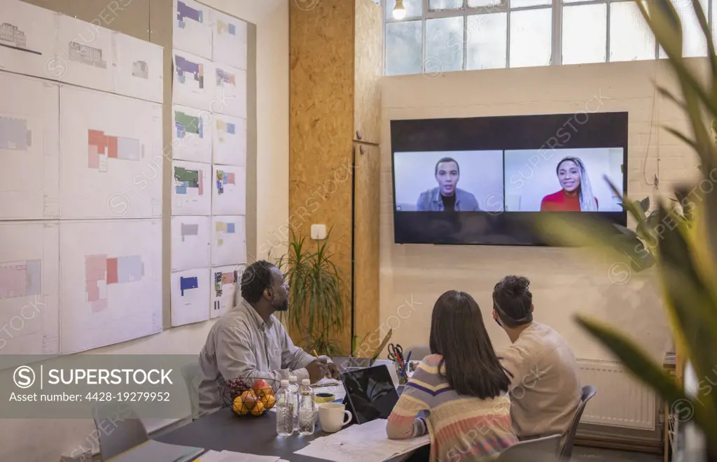 Business people video conferencing with colleagues in meeting