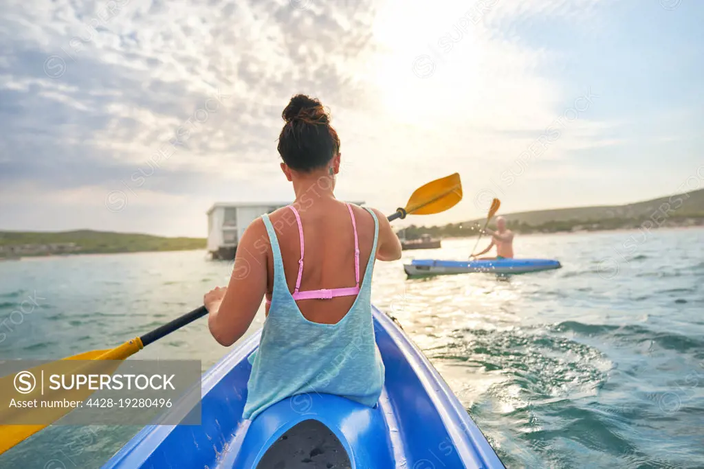 Couple kayaking on sunny summer lake