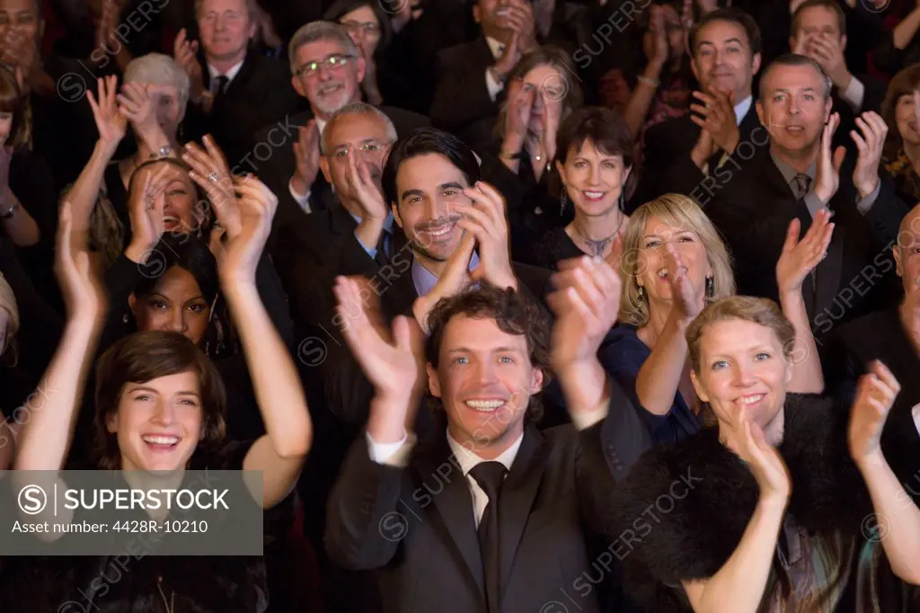Happy audience clapping in theater