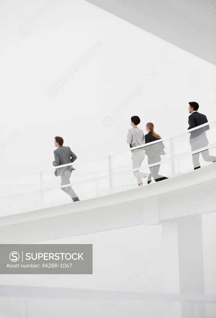 Spain, Business people running down elevated walkway