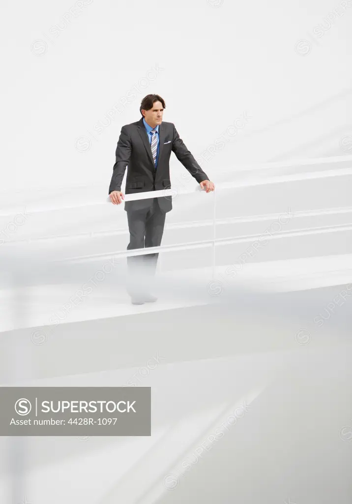 Spain, Businessman leaning on railing at elevated walkway