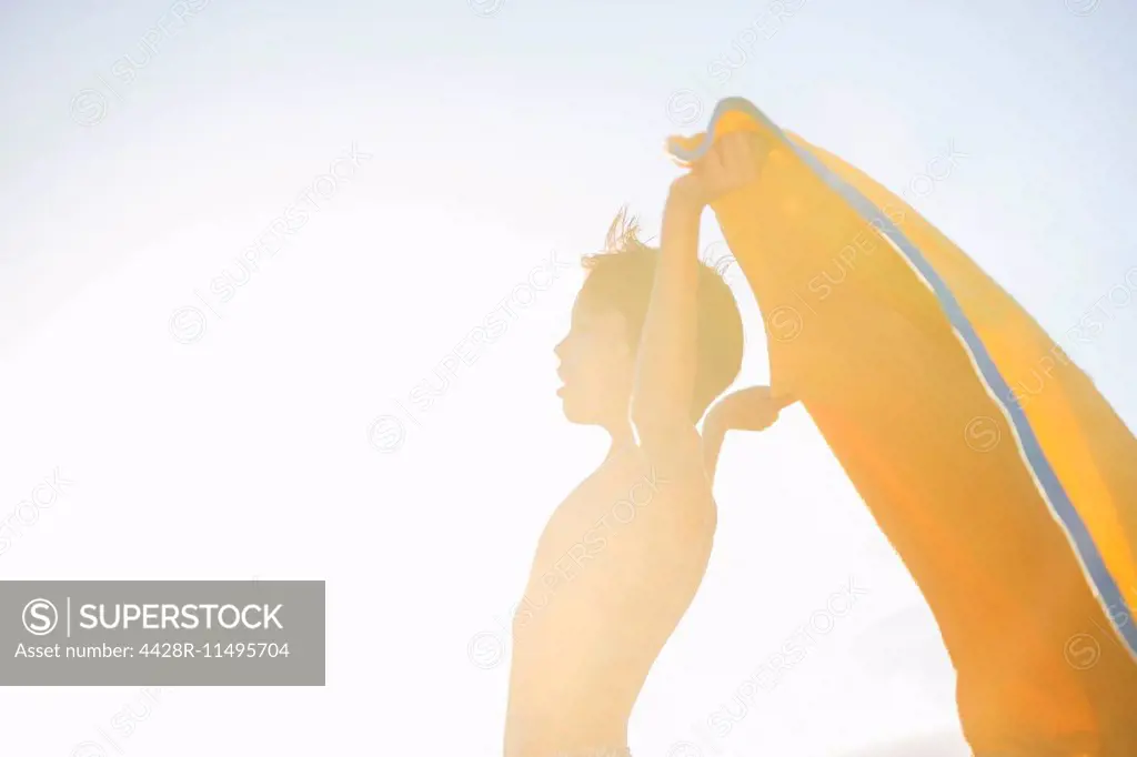 Boy playing with towel on beach