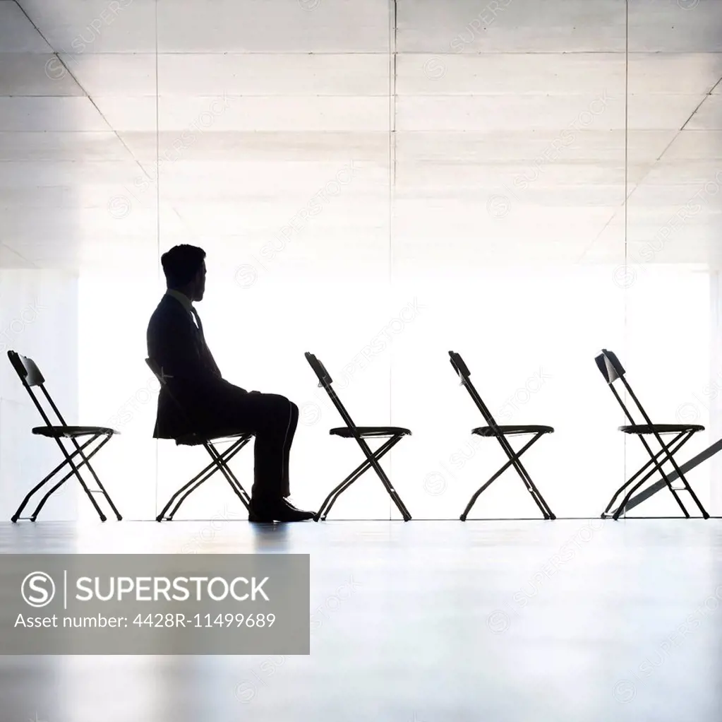 Silhouette of businessman sitting in office