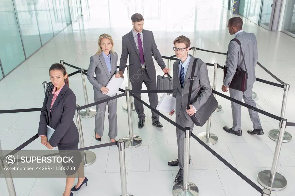 Business people standing in roped-off area