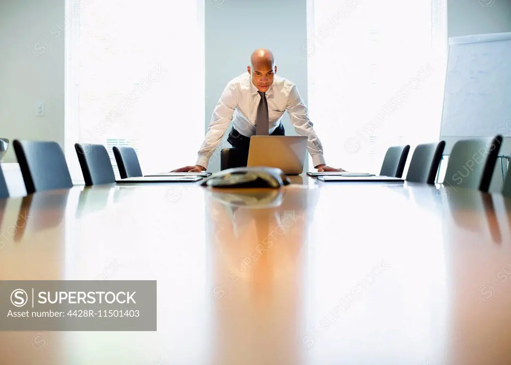 Businessman using laptop at conference table