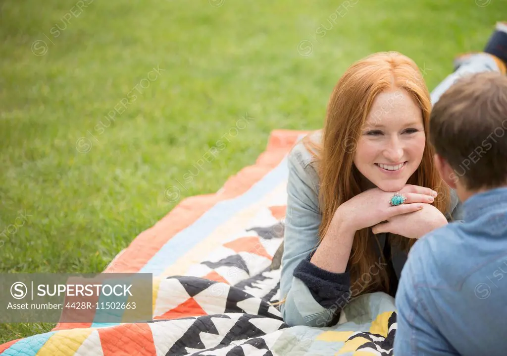 Couple relaxing on blanket in park