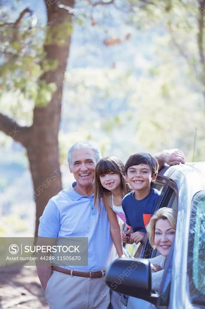 Portrait of happy family inside and outside car