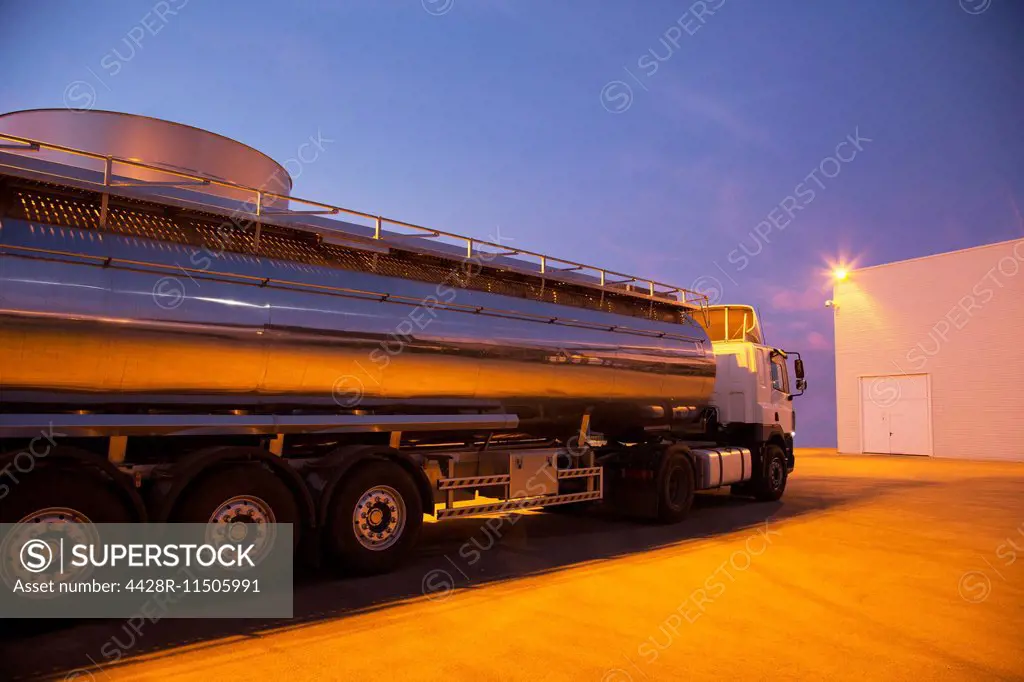 Stainless steel milk tanker parked at night