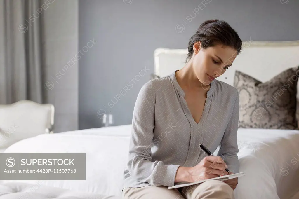 Woman writing in bedroom