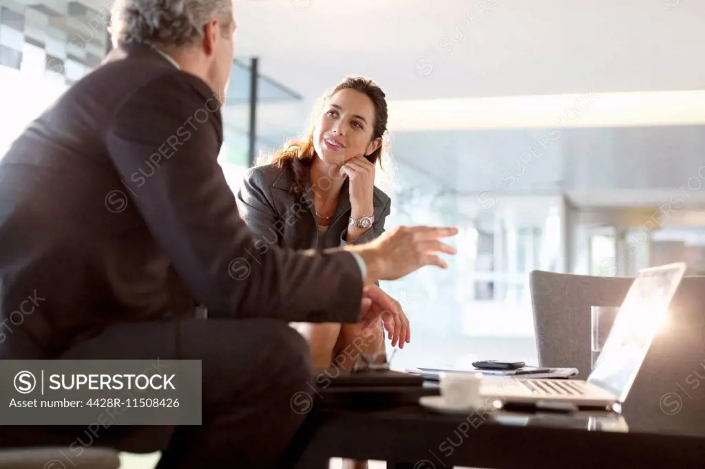Businessman and businesswoman talking in lobby