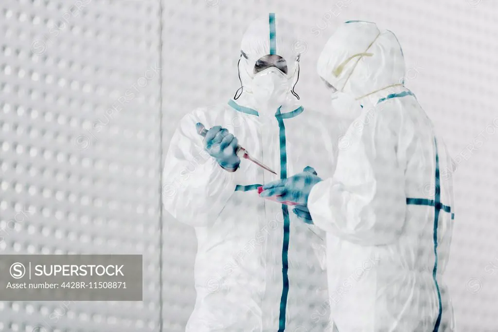 Scientists in clean suits working in laboratory