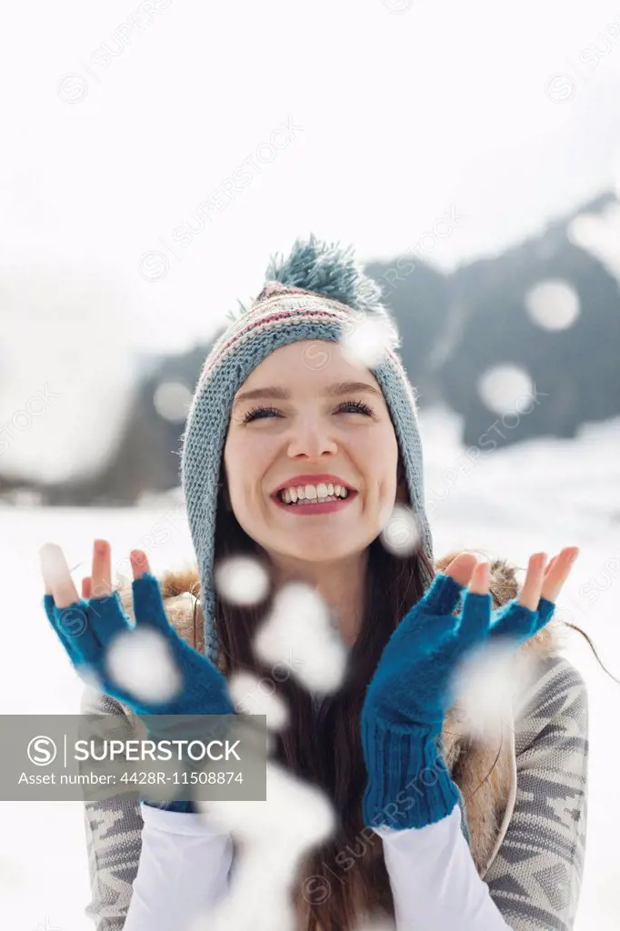 Happy woman watching snow fall