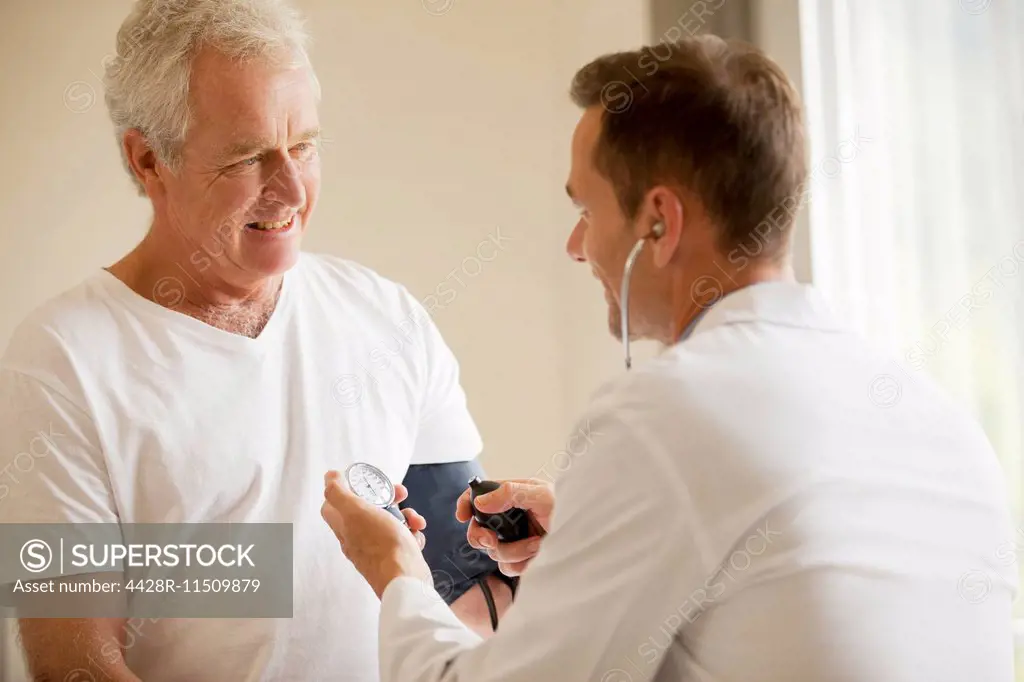Doctor checking senior man's blood pressure in doctor's office