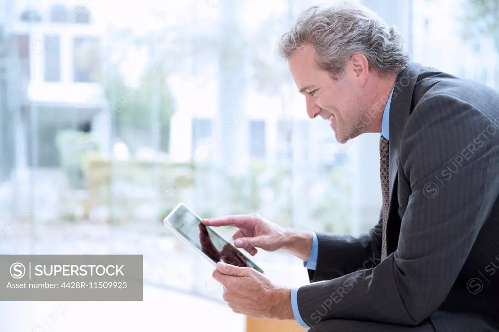 Smiling businessman using digital tablet