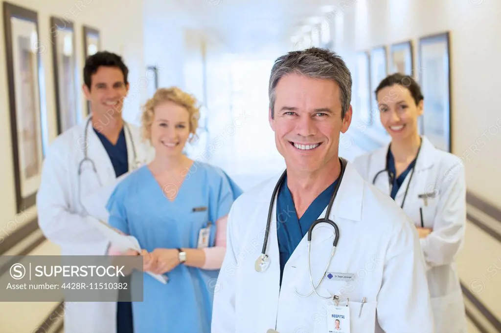 Portrait of smiling doctors and nurse in hospital corridor