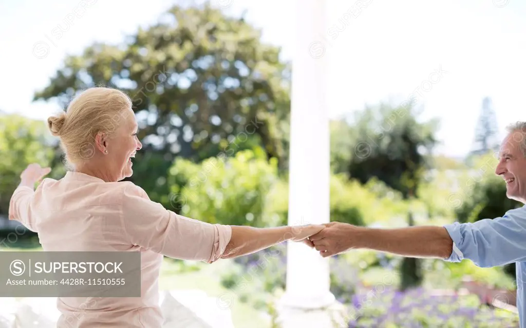 Senior couple dancing on patio