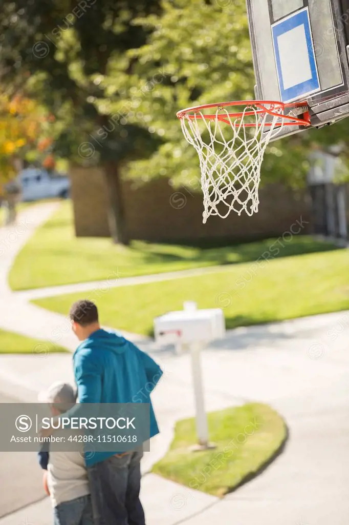 Father and son hugging near basketball hoop