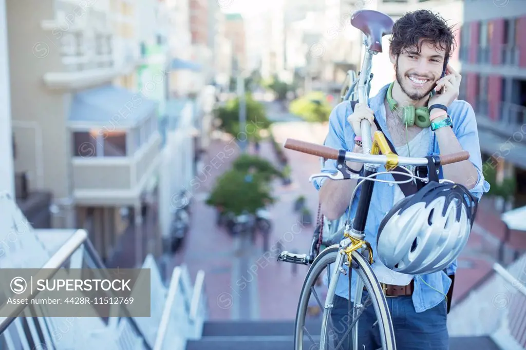 Man carrying bicycle on city steps