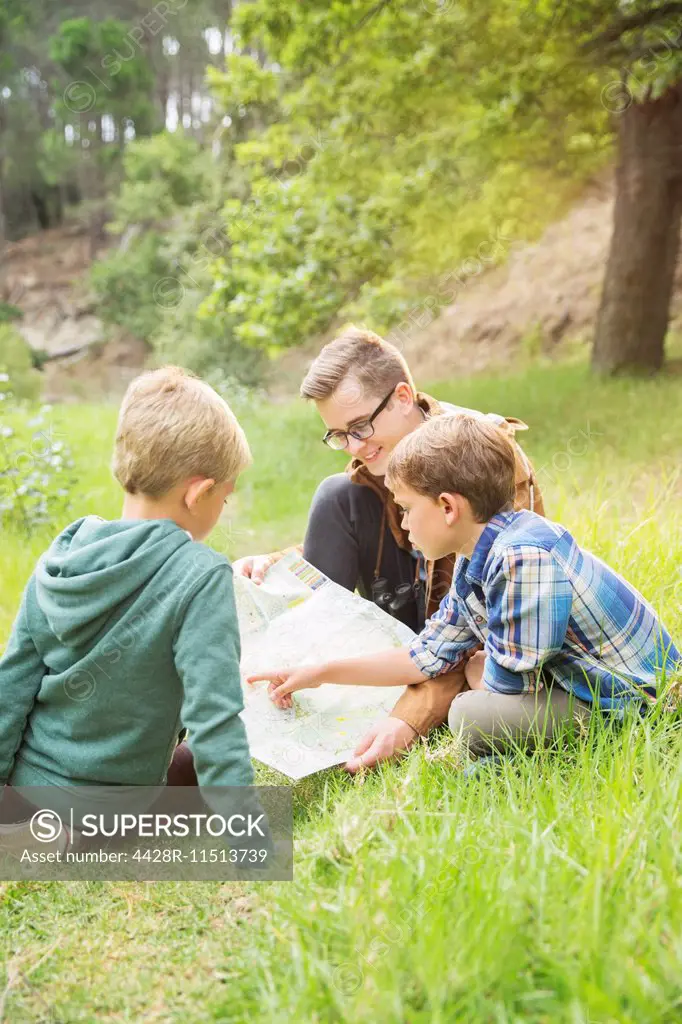 Students and teacher reading map in field
