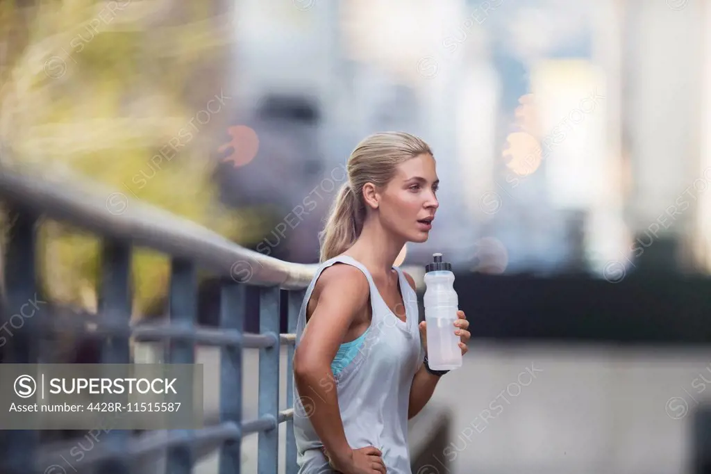 Woman resting after exercising on city street