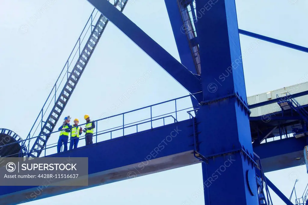Low angle view of workers on cargo crane
