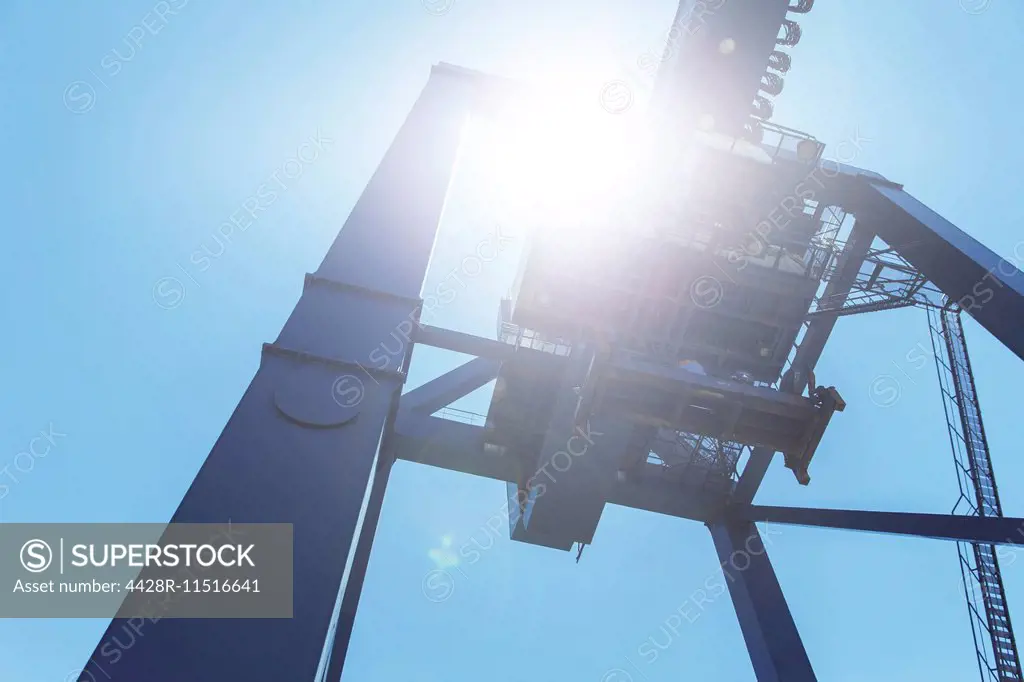 Low angle view of cargo crane against blue sky