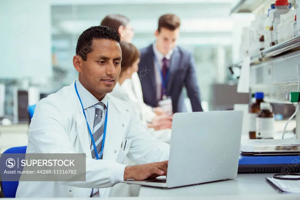 Scientist using laptop in laboratory