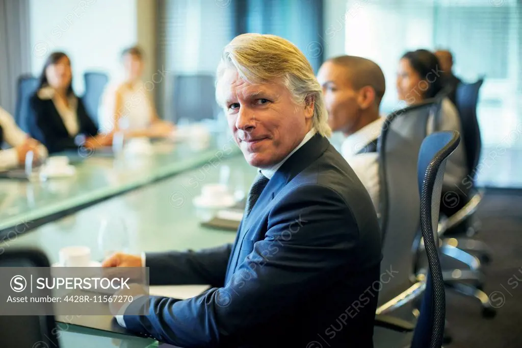 Portrait of businessman sitting at conference table in conference room