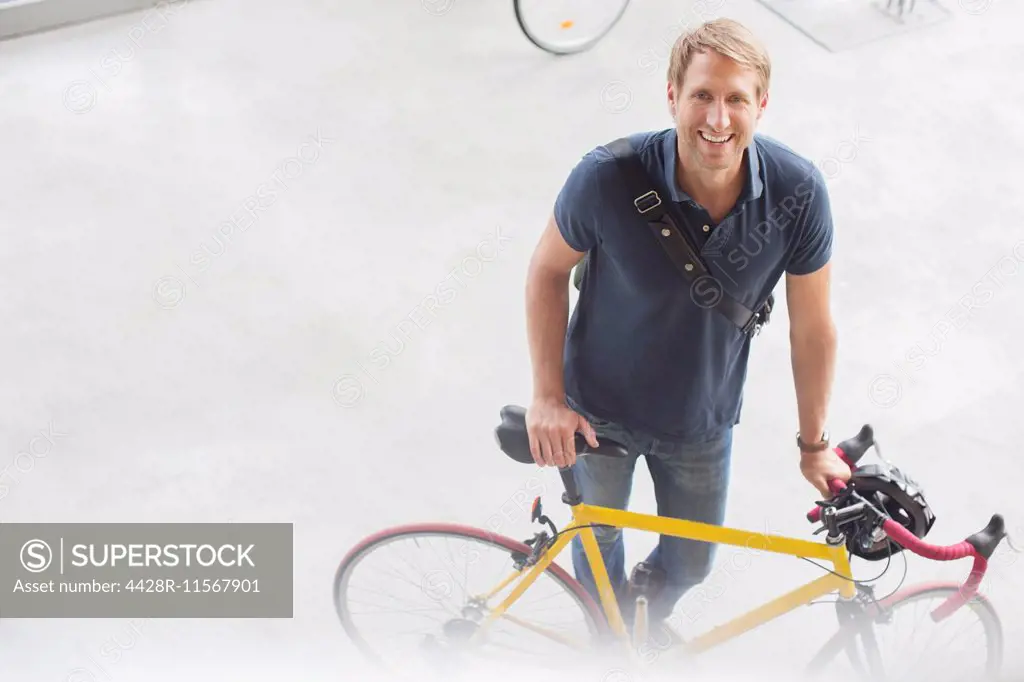 Smiling man standing with bicycle