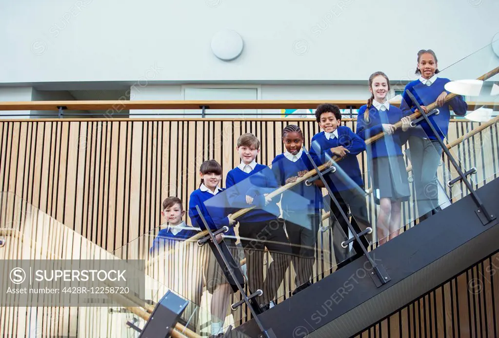 Portrait of elementary school children wearing blue school uniforms standing on steps in school